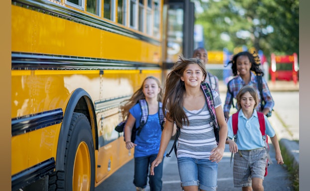 Children running in front of school bus