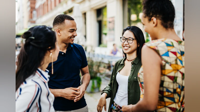 Four friends standing outside having a conversation