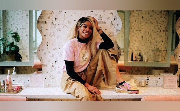 A photo of Elyse Fox sitting on a counter and smiling