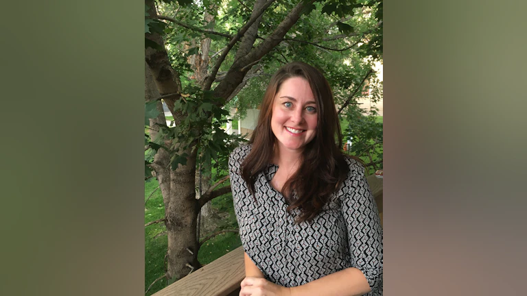 Woman smiling in front of tree