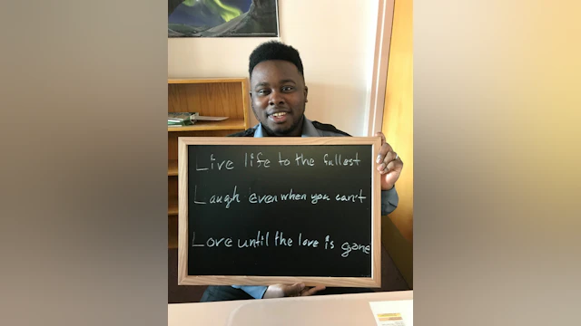 man holding chalkboard