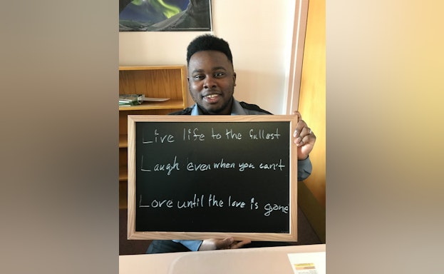 man holding chalkboard