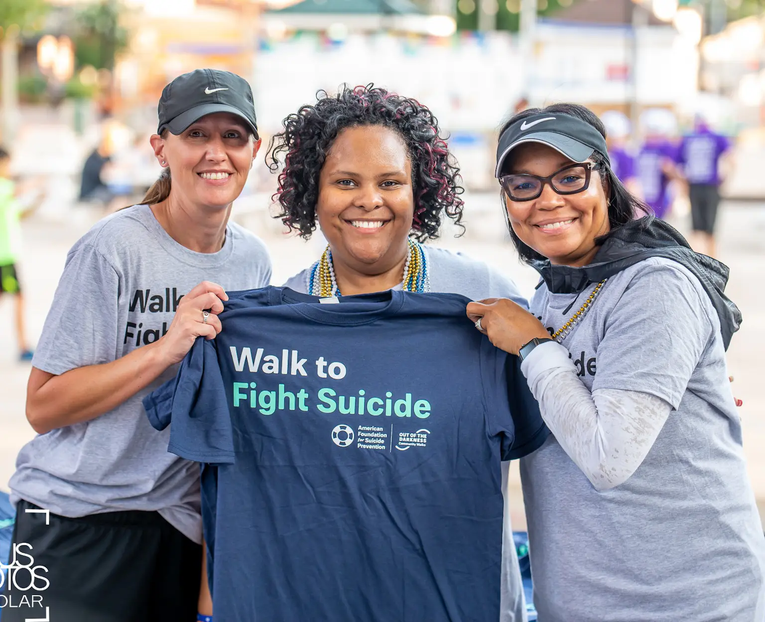 Volunteers holding Walk to Fight Suicide shirt