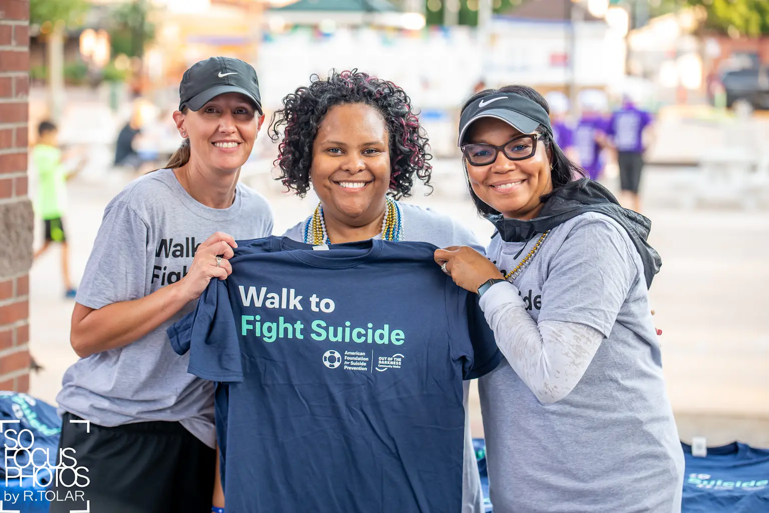 Volunteers holding Walk to Fight Suicide shirt