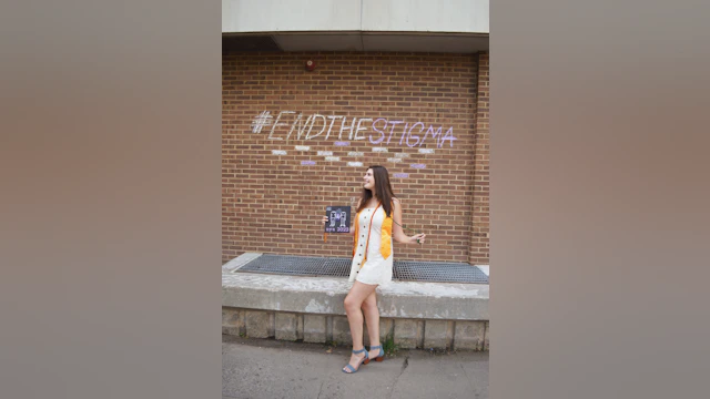 Woman in front of brick wall