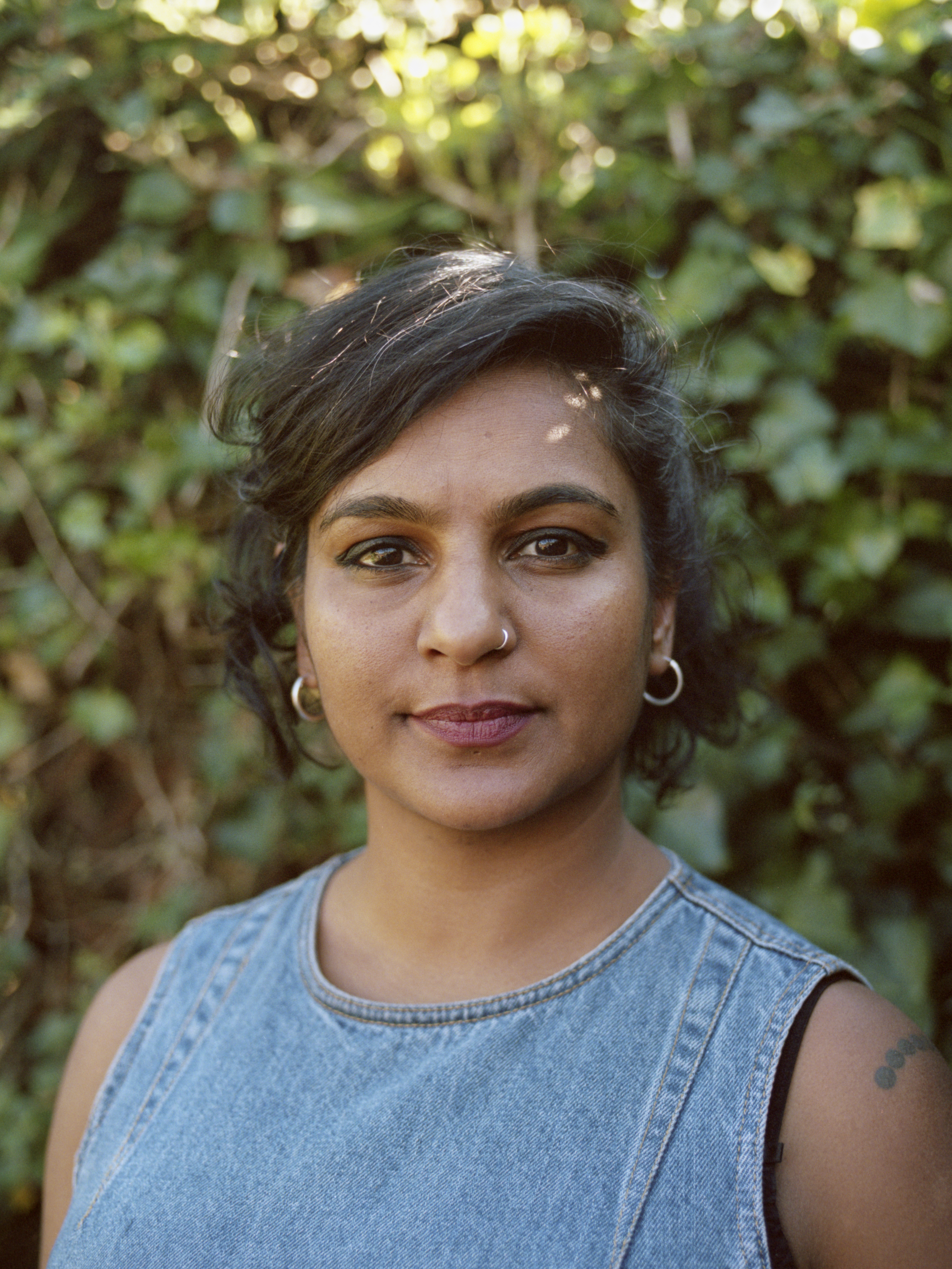 Woman in front of vine wall