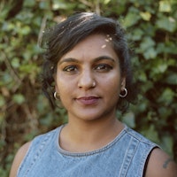 Woman in front of vine wall