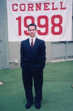 Man in front of Cornell banner