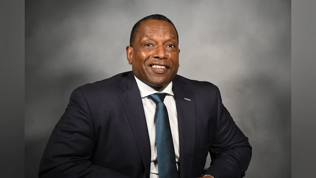 Photo of Victor Armstrong wearing a suit and smiling at the camera