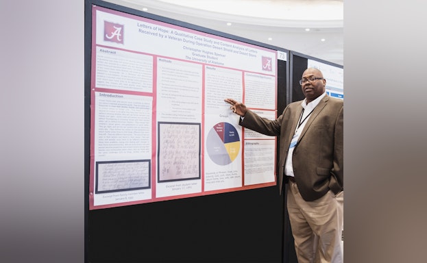 Researcher pointing to poster