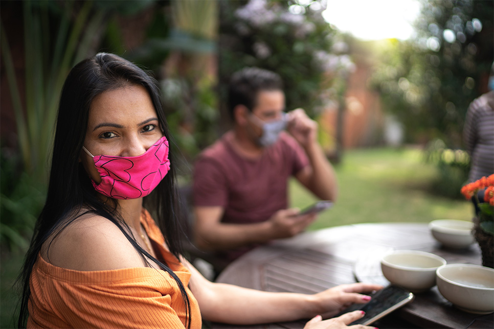 Woman at outdoor table with mask