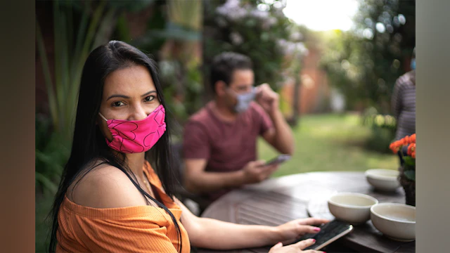Woman at outdoor table with mask