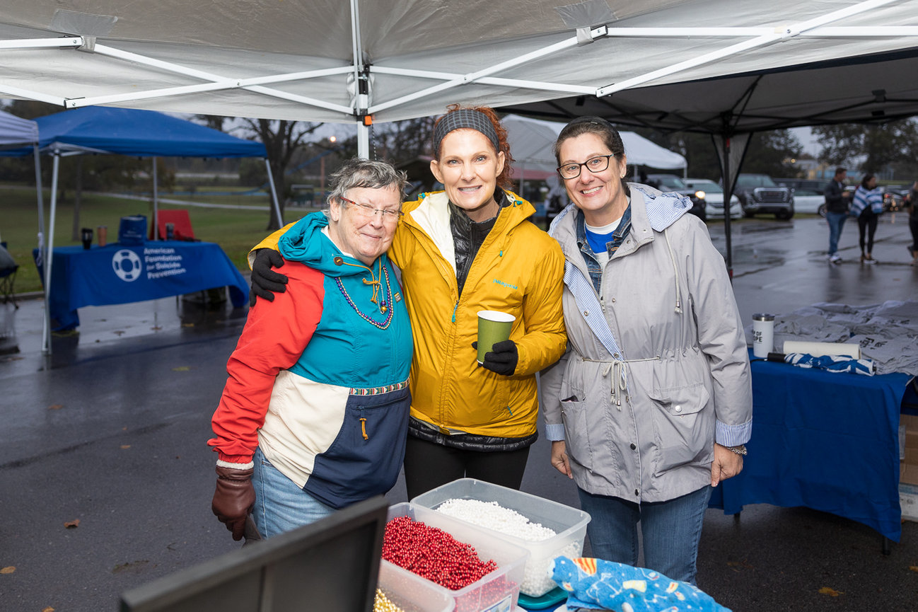 Three women standing under a tent