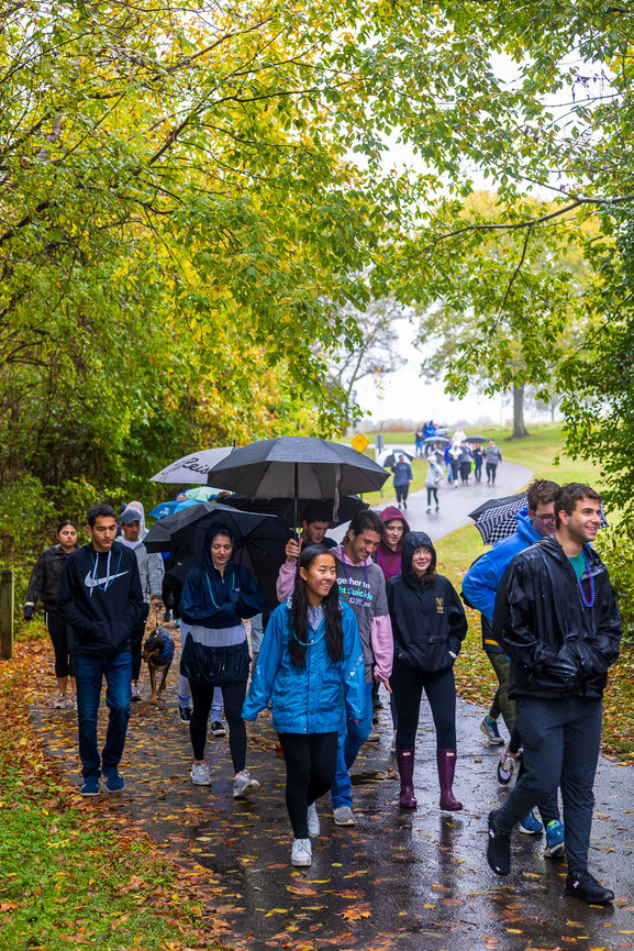 A group of people walk with umbrellas in the rain.