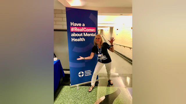 Wendy Sefcik smiling in front of a tall #RealConvo banner