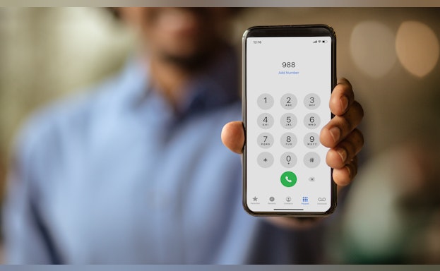 Man holding phone ready to dial 988