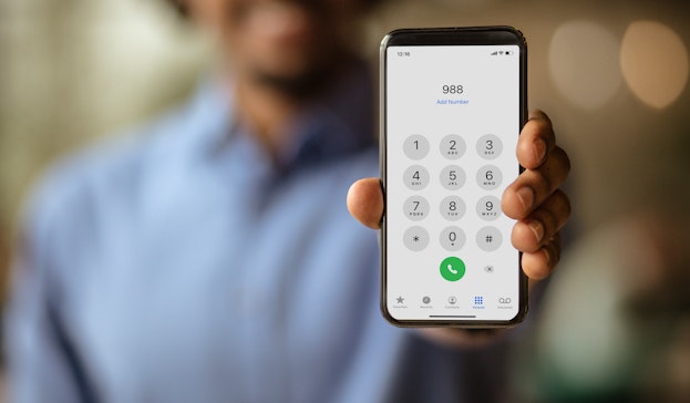 Man holding phone ready to dial 988