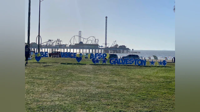 A standing sign that reads, "Be the voice for Galveston"