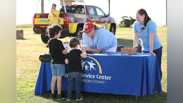 Two children at a merchandise table at the Hike for Hope event in Galveston, Texas