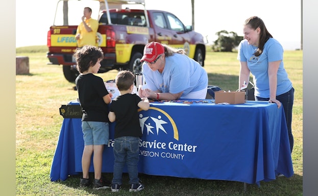 Two children at a merchandise table at the Hike for Hope event in Galveston, Texas