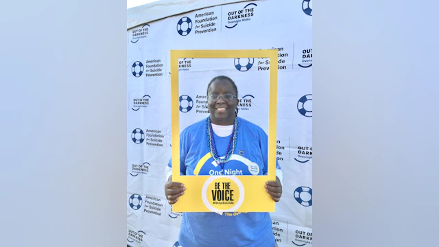 Catharyn Turner posing with a "Be The Voice" photo frame at an Out of The Darkness walk