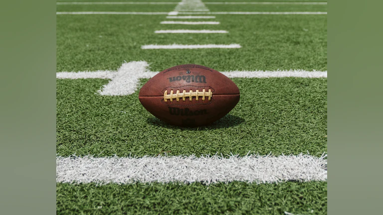 Football laying on turf field