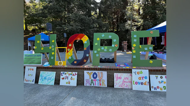 Large wooden hope letters, with smaller signs below with hopeful messages.