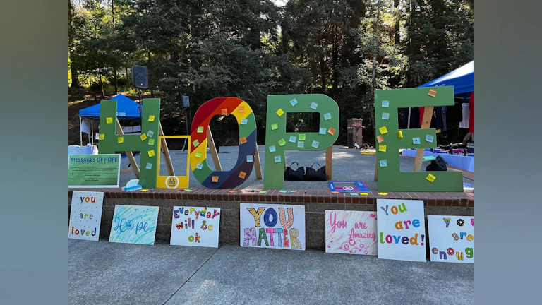 Large wooden hope letters, with smaller signs below with hopeful messages.