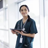 Nurse standing against a window