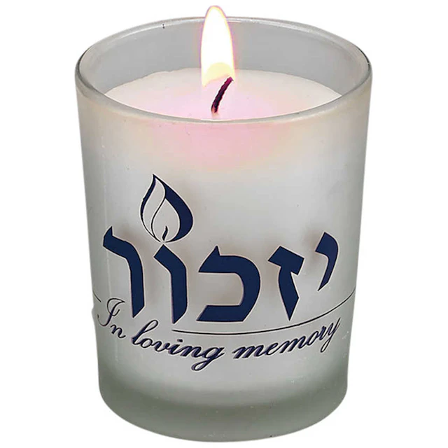 Lit yahrzeit candle that says "In loving memory"