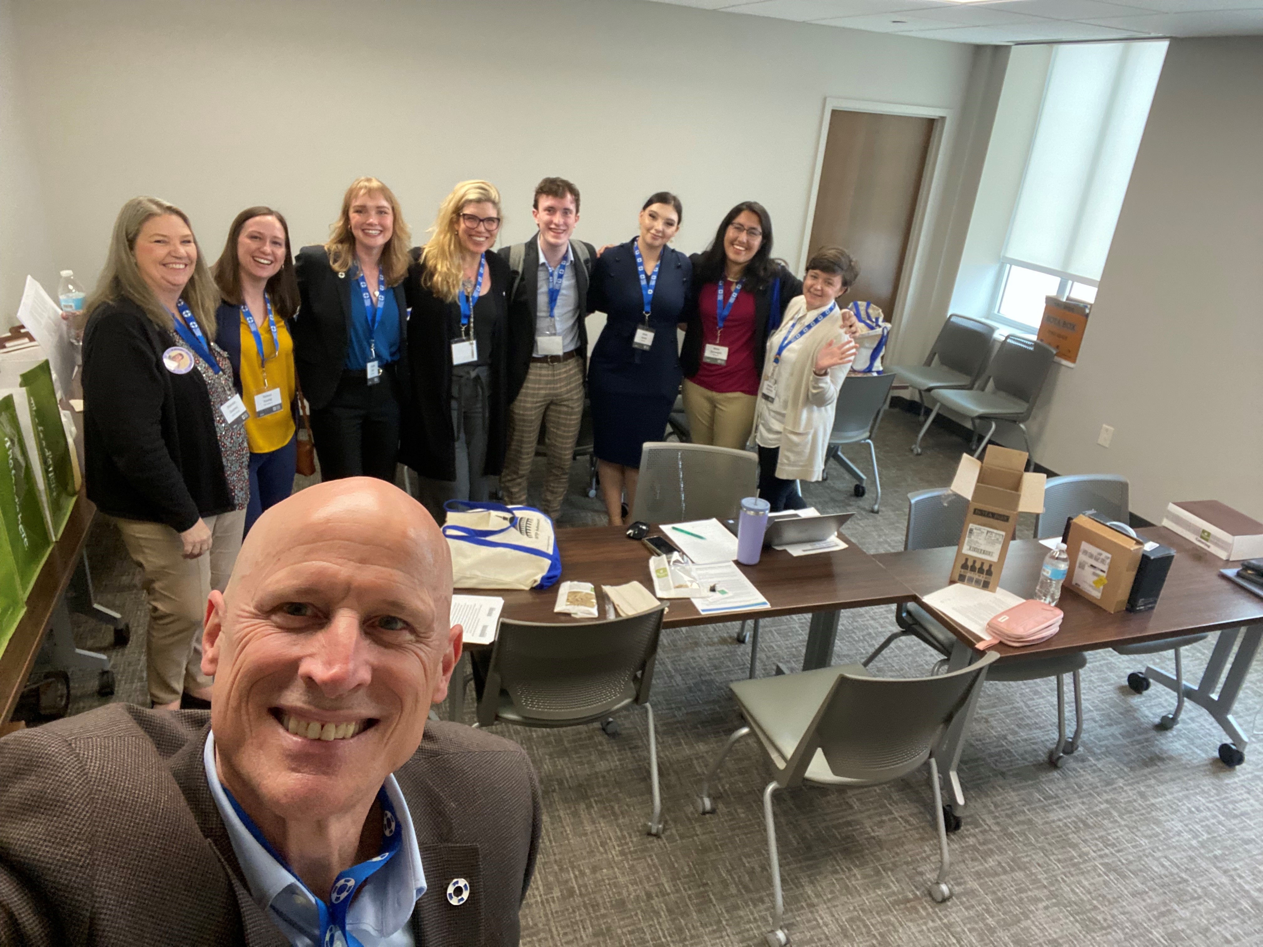 A group of people pose for a photo in a conference room.