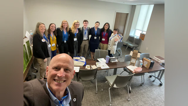 A group of people pose for a photo in a conference room.