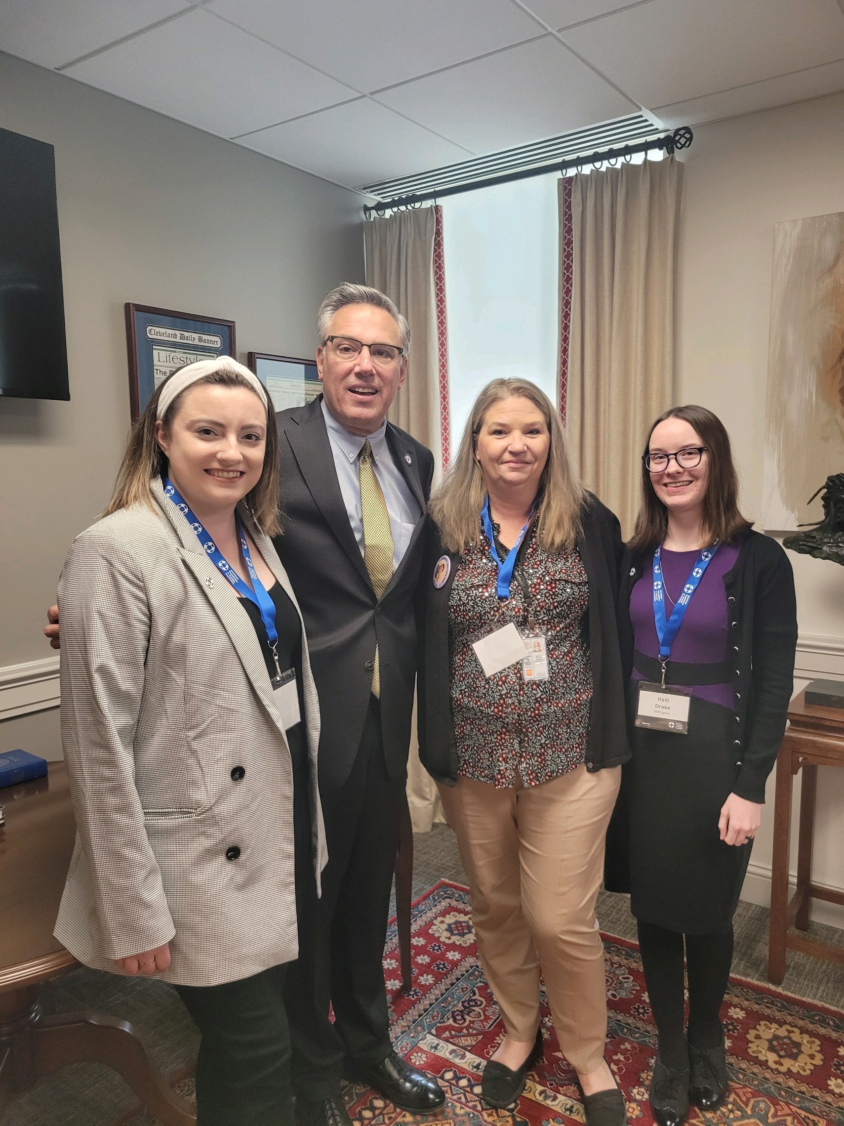 Three advocates pose with a state legislator.