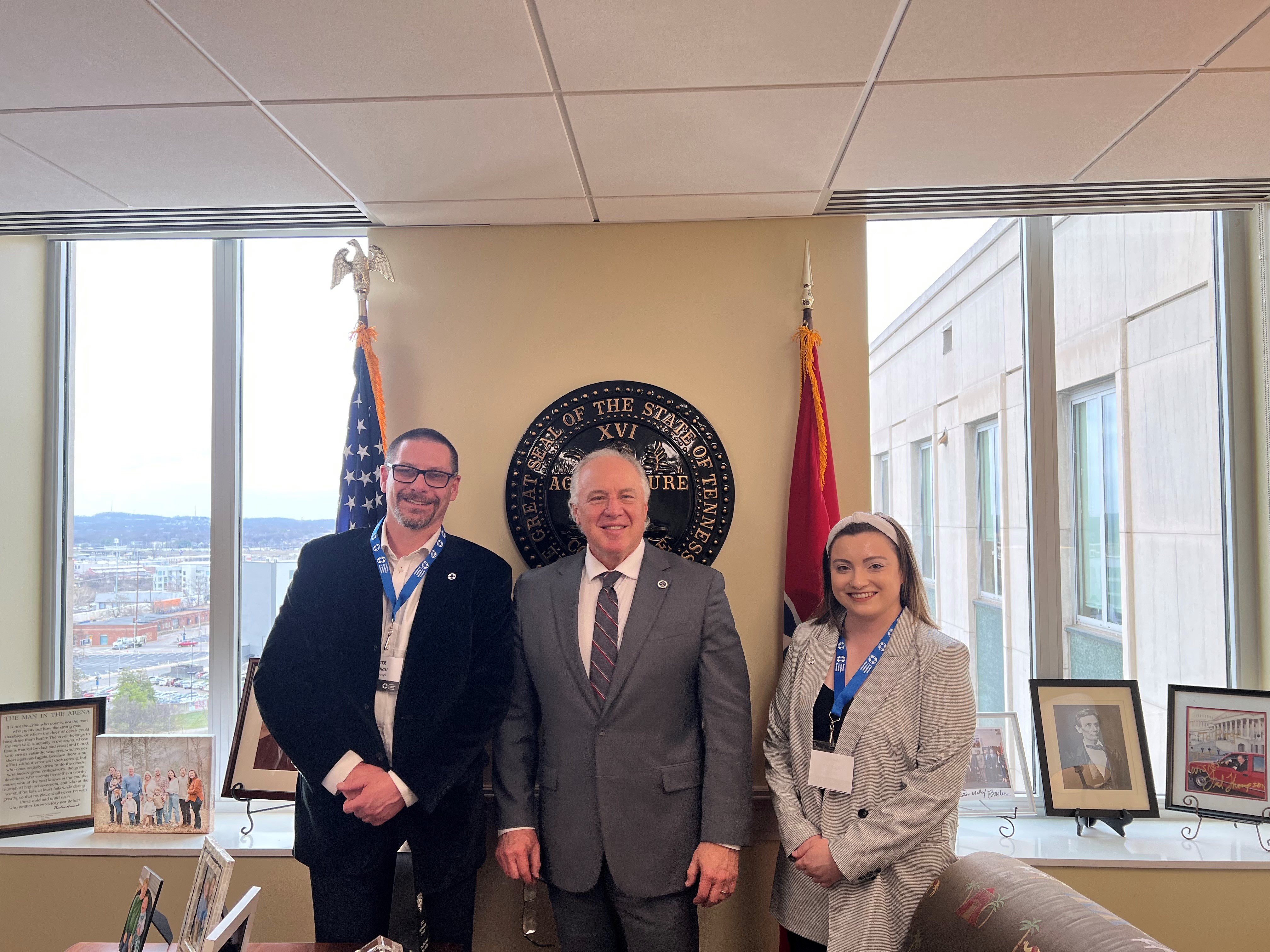 Two advocates pose with a state legislator.