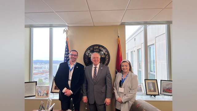 Two advocates pose with a state legislator.
