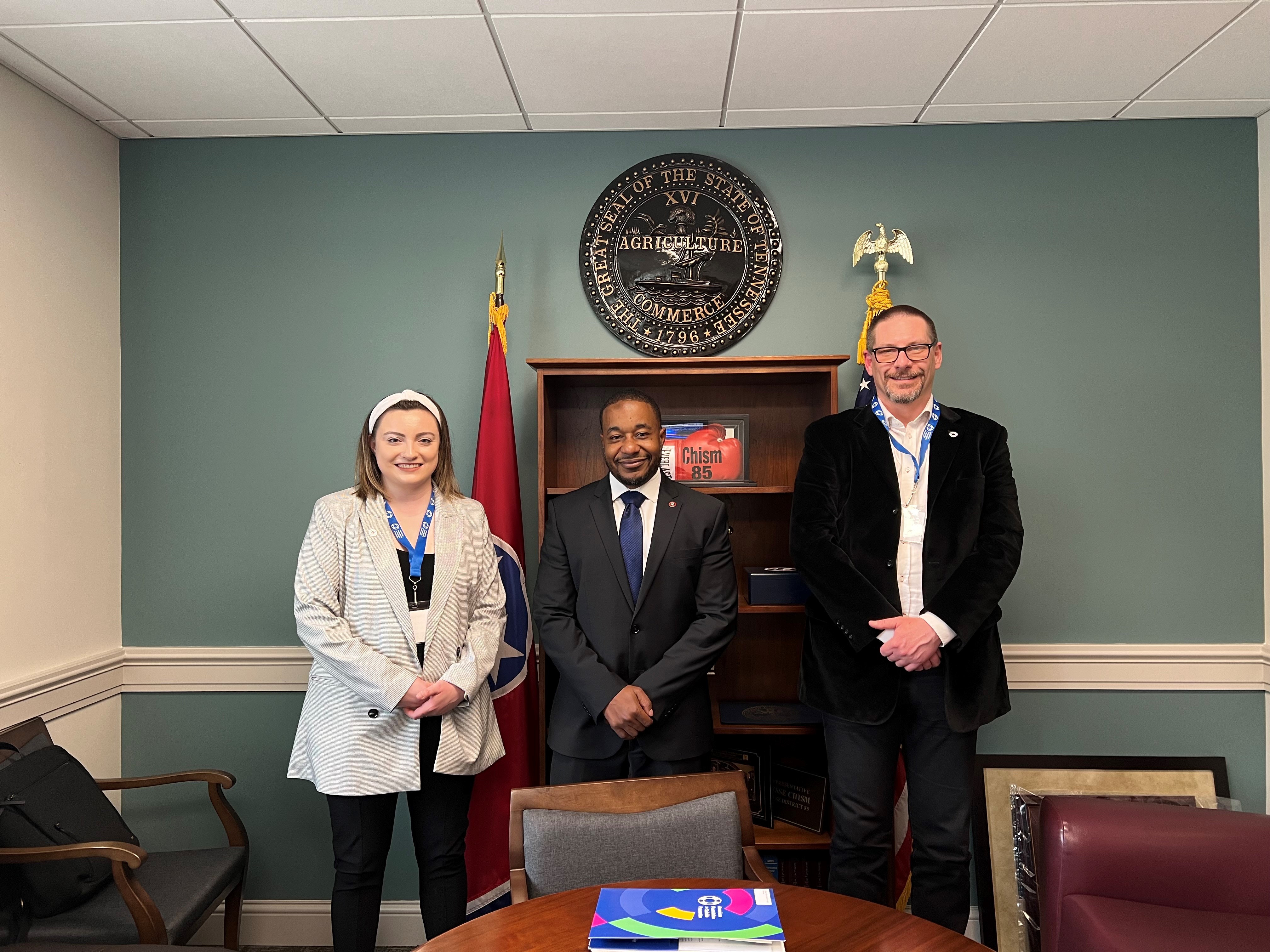 Two advocates pose with a state legislator.