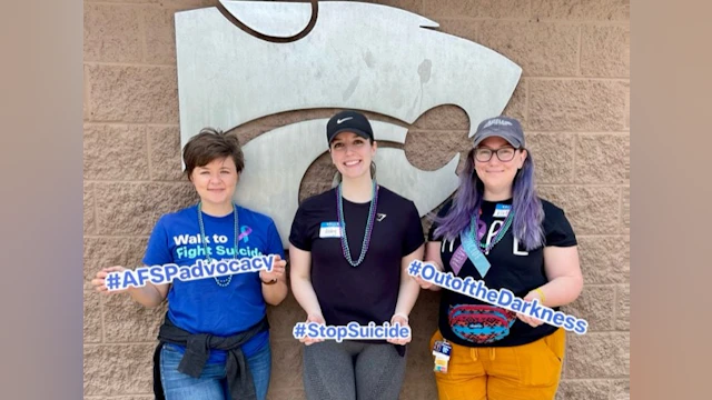 Three women holding #hashtag signs for suicide prevention