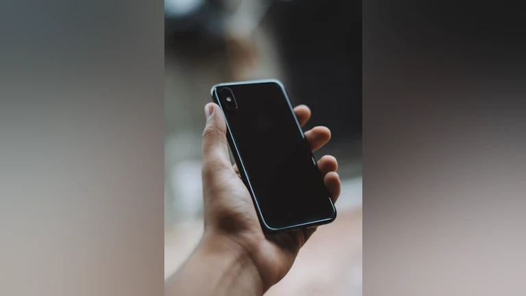 A hand holding a black iphone