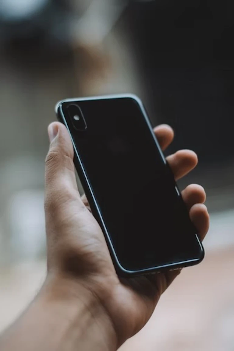 A hand holding a black iphone