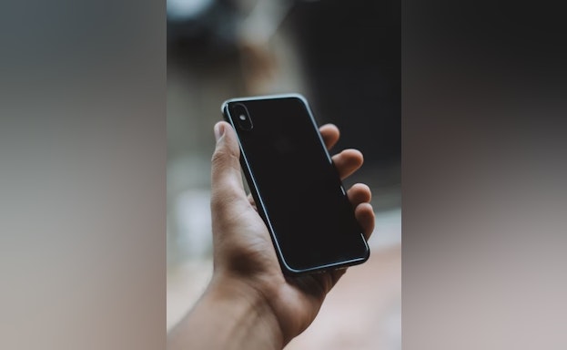 A hand holding a black iphone