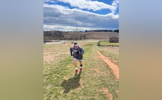 Raymond Burke running up a grassy hill to train for AFSP's Out of the Darkness Overnight Walk.