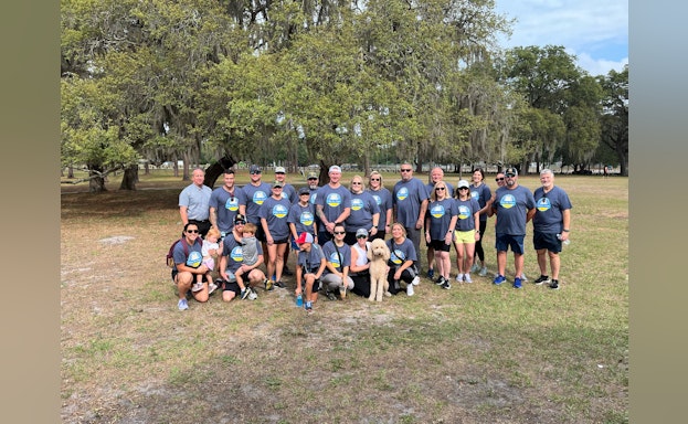 Group of people gathered outside in matching t-shirts at the Construction Hike for Hope.