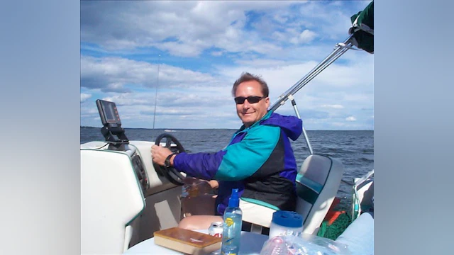 Jenniffer Moffett's stepdad Tom smiling and driving a boat.