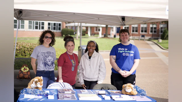 A group of people pose for a photo under a tent