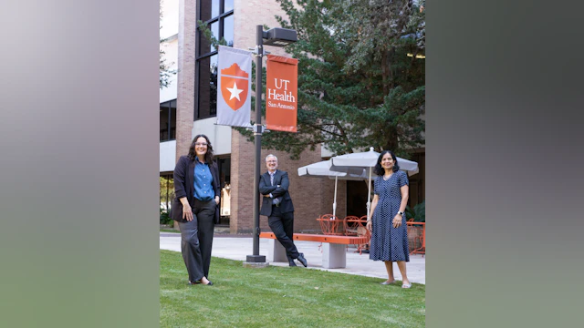 UT Health physicians stand outside on grass and smile at the camera
