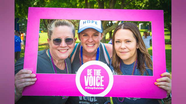 Three women holding a photo frame "Be the Voice"