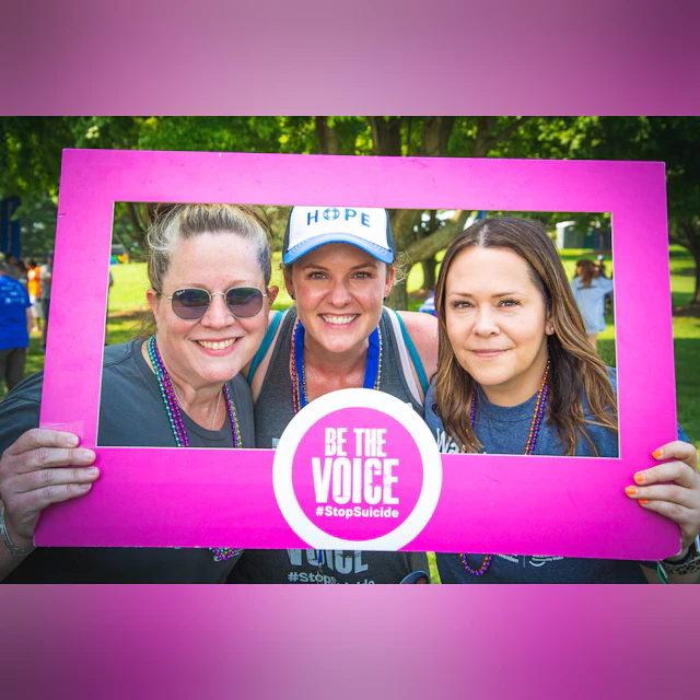 Three women holding a photo frame "Be the Voice"