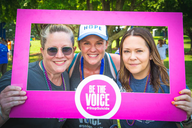 Three women holding a photo frame "Be the Voice"