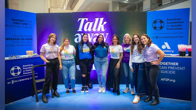 Group of people standing in front of AFSP's "Talk away the dark" sign