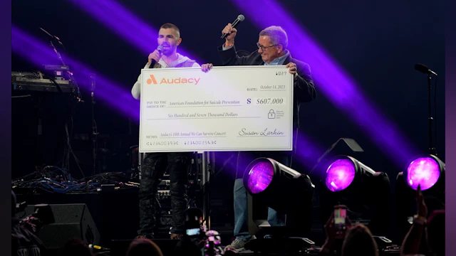 Concert stage featuring oversized check with funds raised for AFSP